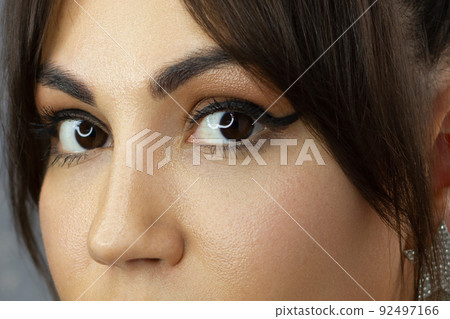 Beautiful macro shot of female eye with classic eyeliner makeup. Perfect shape of eyebrows, brown eyeshadows and long eyelashes. Cosmetics and make-up. Closeup macro shot of fashion liner eyes visage Beautiful macro shot of female eye with classic eyeliner makeup. Perfect shape of eyebrows, brown eyeshadows and long eyelashes. Cosmetics and make-up. Closeup macro shot of fashion liner eyes visage 92497166