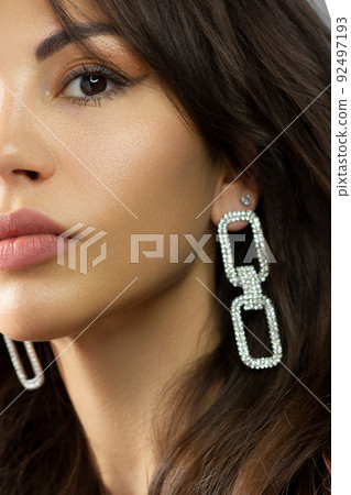 Half a beauty portrait with beautiful fashionable evening make-up, black jiggles on eyes and extremely long eyelashes. Pink lipstick on the lips. Cosmetology and spa facial skin care Half a beauty portrait with beautiful fashionable evening make-up, black jiggles on eyes and extremely long eyelashes. Pink lipstick on the lips. Cosmetology and spa facial skin care 92497193