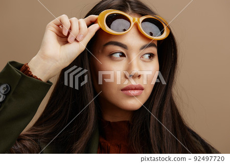 woman jacket sunglasses elegant style fashion beige background 92497720