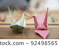 Two origami cranes that stick the beaks together 92498565
