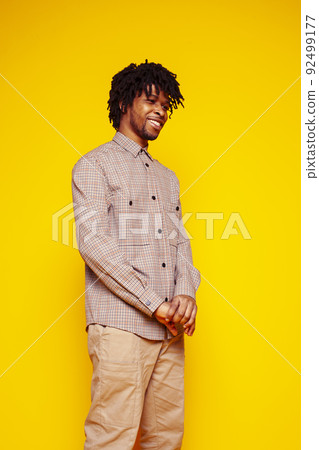 Young handsome african american guy student posing cheerful and gesturing on yellow background, lifestyle people concept close up 92499177
