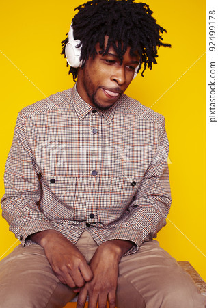 Young handsome african american guy student posing cheerful and gesturing on yellow background, lifestyle people concept close up 92499178