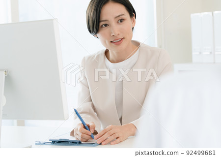 Business woman listening to the client Business woman listening to the client 92499681