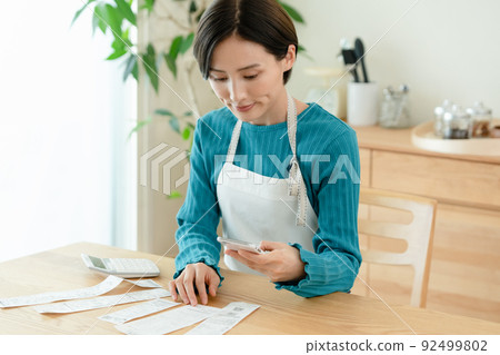 A woman who manages a household budget 92499802