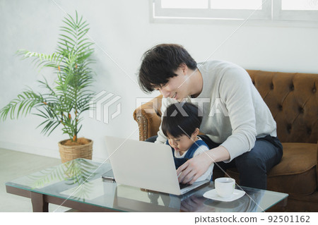 Dad and little boy looking at a computer Dad and little boy looking at a computer 92501162