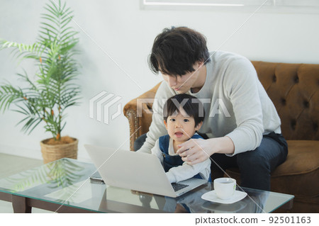 Dad and little boy looking at a computer Dad and little boy looking at a computer 92501163