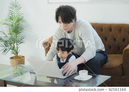 Dad and little boy looking at a computer 92501169
