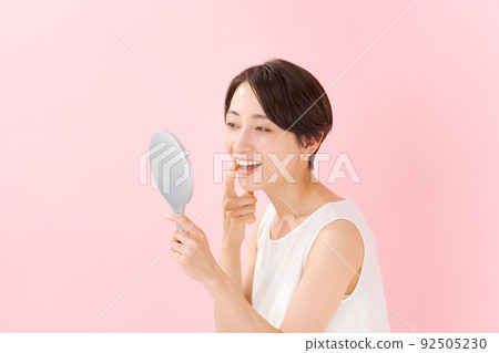 Woman checking teeth Woman checking teeth 92505230