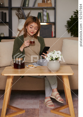 Woman Scrolling Social Media on Smartphone Woman Scrolling Social Media on Smartphone 92507984