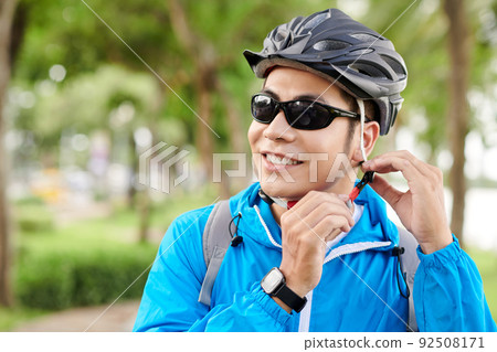 Sportsman Putting on Bicycle Helmet 92508171