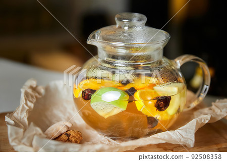 Fruit and berry tea in a transparent glass teapot. Close-up, selective focus Fruit and berry tea in a transparent glass teapot. Close-up, selective focus 92508358