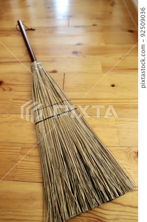 A short-handled broom placed on the floor, a cleaning tool 92509036