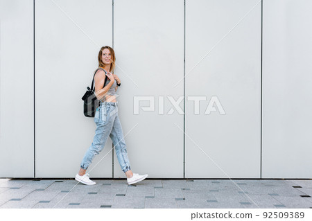 Beautiful casual young woman walking in the street 92509389