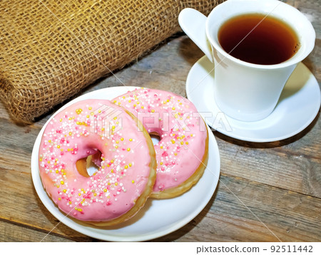 Sweet tasty donuts with sprinkling and fragrant tea. Sweet tasty donuts with sprinkling and fragrant tea. 92511442