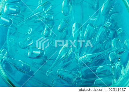 Glass medical ampoule vial for injection. Medicine is liquid sodium chloride with of aqueous solution in ampulla. Close up. Bottles ampule multicolor. Glass medical ampoule vial for injection. Medicine is liquid sodium chloride with of aqueous solution in ampulla. Close up. Bottles ampule multicolor. 92511687