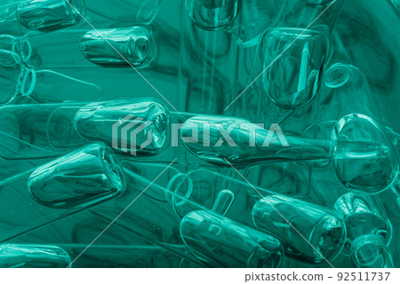 Glass medical ampoule vial for injection. Medicine is liquid sodium chloride with of aqueous solution in ampulla. Close up. Bottles ampule multicolor. 92511737