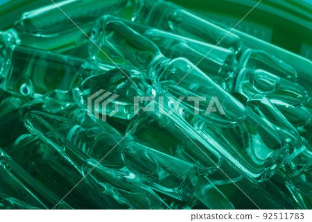 Glass medical ampoule vial for injection. Medicine is liquid sodium chloride with of aqueous solution in ampulla. Close up. Bottles ampule multicolor. Glass medical ampoule vial for injection. Medicine is liquid sodium chloride with of aqueous solution in ampulla. Close up. Bottles ampule multicolor. 92511783