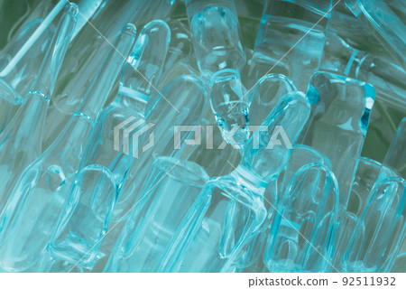 Glass medical ampoule vial for injection. Medicine is liquid sodium chloride with of aqueous solution in ampulla. Close up. Bottles ampule multicolor. 92511932