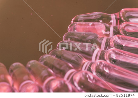 Glass medical ampoule vial for injection. Medicine is liquid sodium chloride with of aqueous solution in ampulla. Close up. Bottles ampule multicolor. Glass medical ampoule vial for injection. Medicine is liquid sodium chloride with of aqueous solution in ampulla. Close up. Bottles ampule multicolor. 92511974