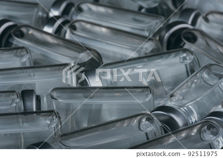 Glass medical ampoule vial for injection. Medicine is dry white drug penicillin powder or liquid with of aqueous solution in ampulla. Close up. Glass medical ampoule vial for injection. Medicine is dry white drug penicillin powder or liquid with of aqueous solution in ampulla. Close up. 92511975