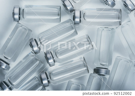 Glass medical ampoule vial for injection. Medicine is dry white drug penicillin powder or liquid with of aqueous solution in ampulla. Close up. Glass medical ampoule vial for injection. Medicine is dry white drug penicillin powder or liquid with of aqueous solution in ampulla. Close up. 92512002