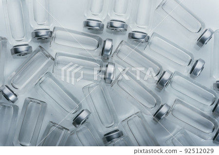 Glass medical ampoule vial for injection. Medicine is dry white drug penicillin powder or liquid with of aqueous solution in ampulla. Close up. 92512029