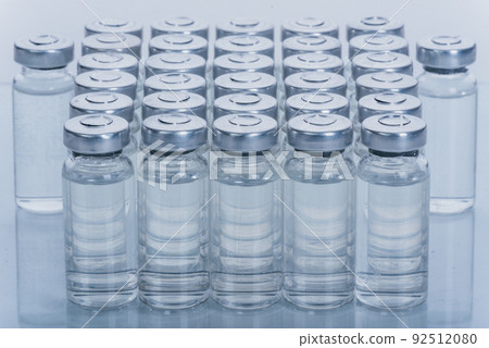 Glass medical ampoule vial for injection. Medicine is dry white drug penicillin powder or liquid with of aqueous solution in ampulla. Close up. 92512080