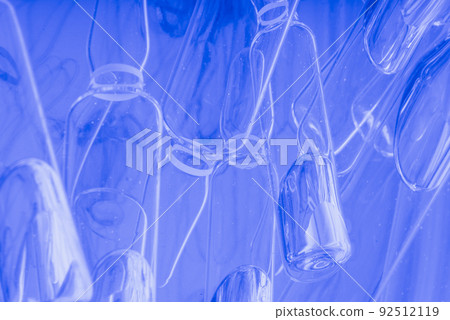 Glass medical ampoule vial for injection. Medicine is liquid sodium chloride with of aqueous solution in ampulla. Close up. Bottles ampule multicolor. 92512119