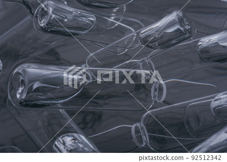 Glass medical ampoule vial for injection. Medicine is liquid sodium chloride with of aqueous solution in ampulla. Close up. Bottles ampule multicolor. Glass medical ampoule vial for injection. Medicine is liquid sodium chloride with of aqueous solution in ampulla. Close up. Bottles ampule multicolor. 92512342