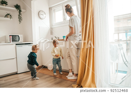 Kids and their mother in the kitchen Kids and their mother in the kitchen 92512468