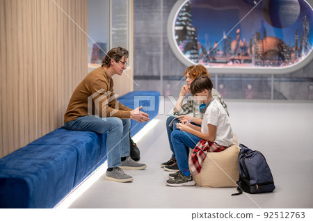 Teacher talking to his students in the school space 92512763