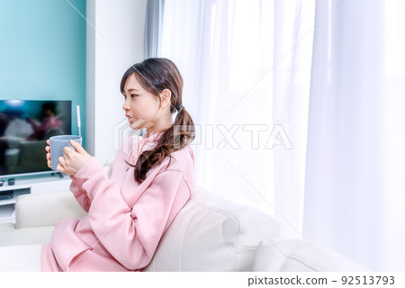 Young woman relaxing with a cup of coffee in the morning Young woman relaxing with a cup of coffee in the morning 92513793