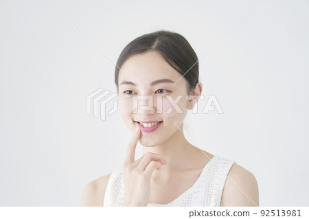 一個女人用白色背景指著她的嘴 92513981