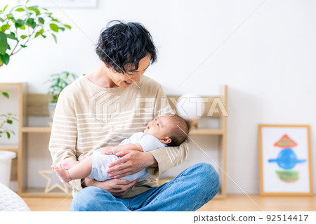 Young dad holding a baby 92514417