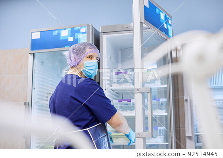 The scientist takes samples of materials for experiments out of the refrigerator 92514945