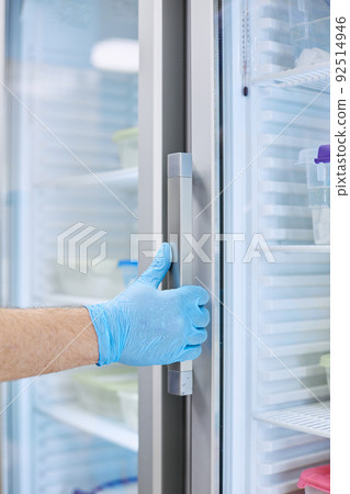 The scientist takes samples of materials for experiments out of the refrigerator 92514946