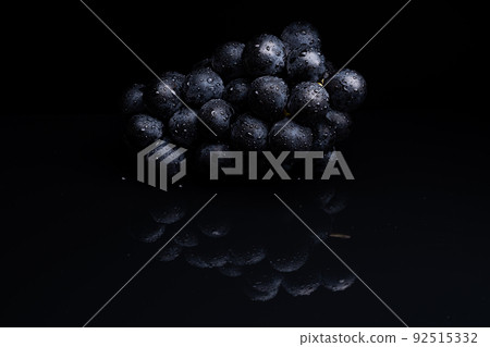 Photo taken on a black reflective background of large grapes 92515332