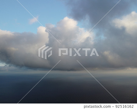 Abstract aerial nature summer ocean sunset sea and sky background. Small waves on clear water surface in motion blur with bokeh lights from sunrise. Holiday, vacation and recreational concept 92516162