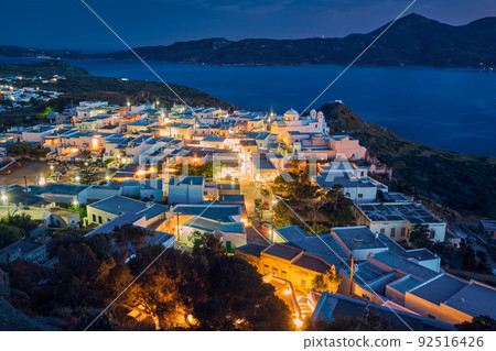 Colorful night view of traditional Greek small town or village by seafront, Plaka, Milos island, Cyclades, Greece.  92516426