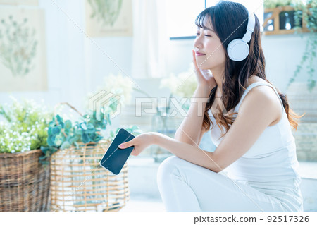 Young woman listening to smartphone music with headphones 92517326