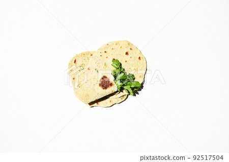 Flat lay homemade chapati, pita bread, flatbread with parsley, isolated over white background. Still life. Copy space 92517504