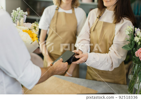 Close up of caucasian male hands using electronic credit card on his smartphone paying for purchase 92518336