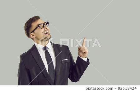 Funny crazy businessman thinks of a good business idea, points his finger up and smiles 92518424