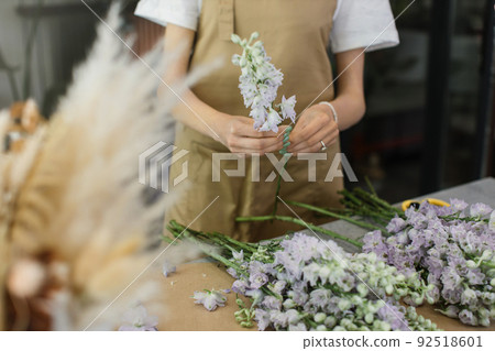 Gardener's in the flower shop make bouquet for a holiday. Gardener's in the flower shop make bouquet for a holiday. 92518601