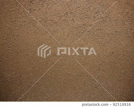 Horizontal background image of the surface where the rough texture of straw remains in the dark brown soil wall 92518916