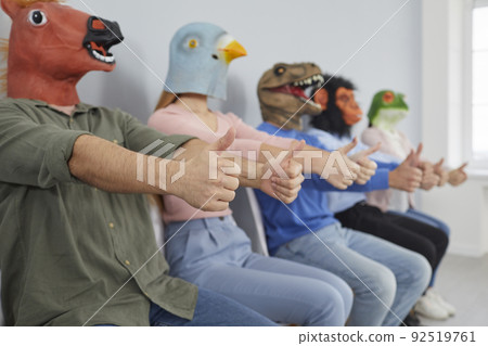 Group of strange men and women wearing funny animal masks giving thumbs up together Group of strange men and women wearing funny animal masks giving thumbs up together 92519761