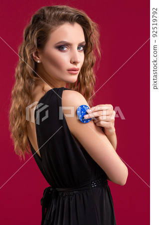 Pretty long hair woman holding chips for gambling. Studio shot 92519792