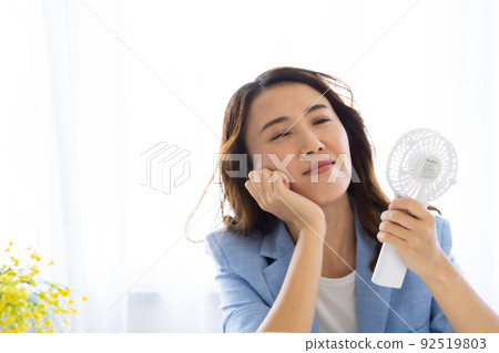 一個用風扇冷卻的女人 92519803