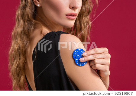 Portrait of a beautiful young woman with poker chips on red background 92519807