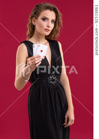 Beautiful young woman with a playing cards on red background 92519861